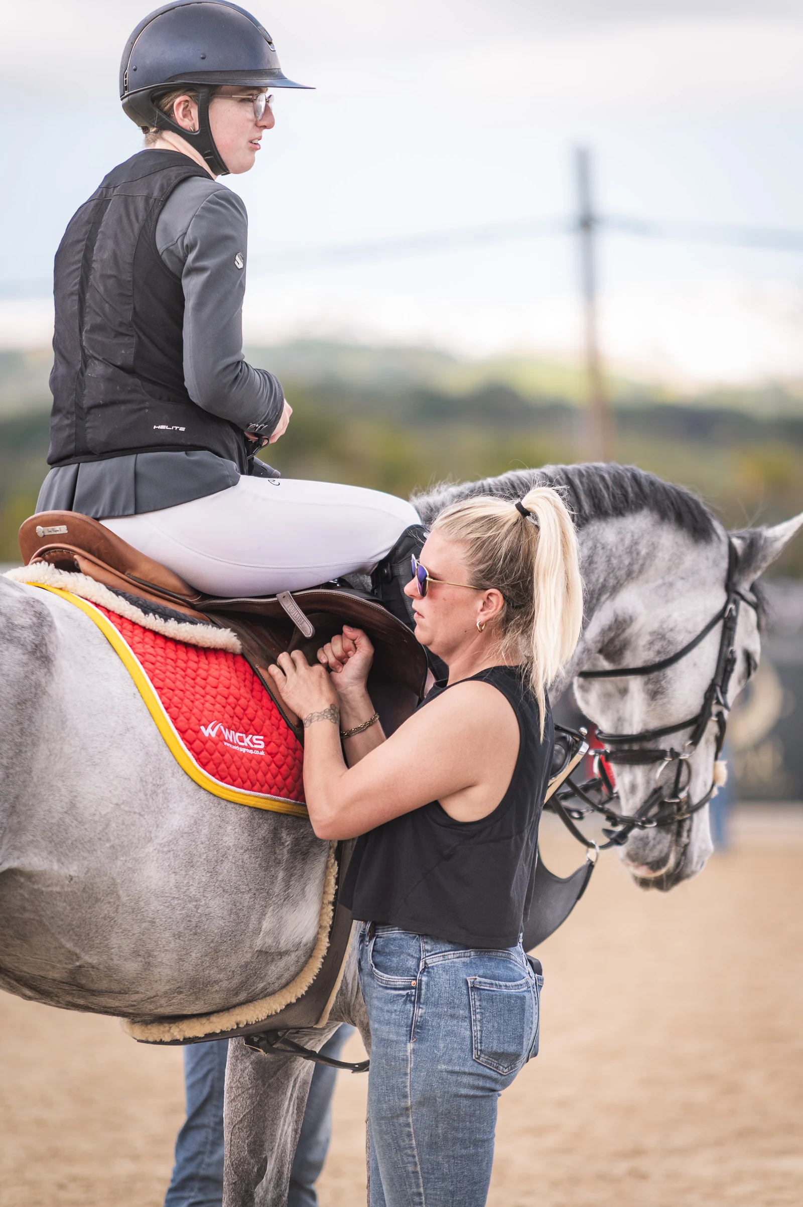 Preparing a horse’s tack with the rider mounted